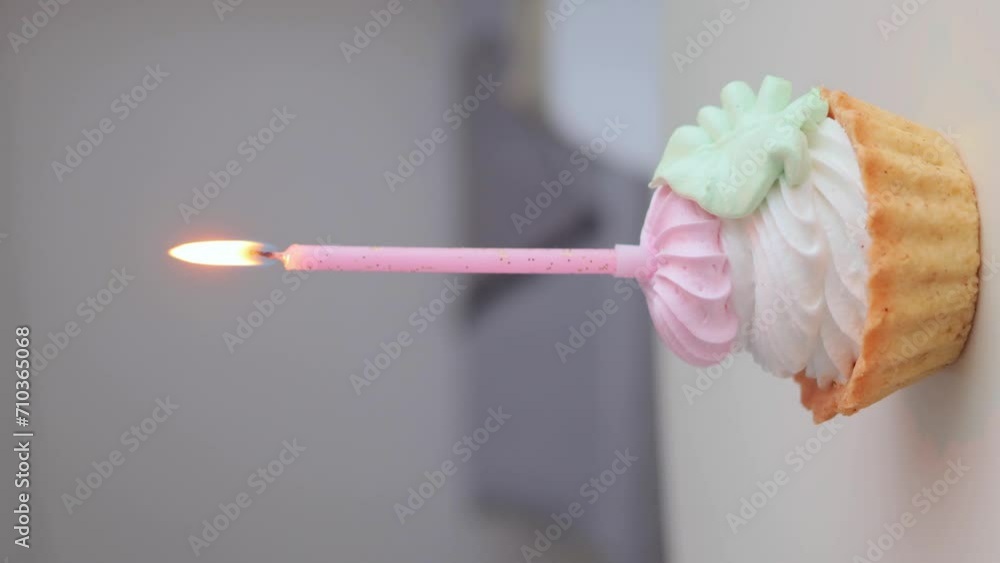 Vertical video. Delicious birthday cupcake with burning candle on table in light room interior background, copy space for advertisement Vertical video. Delicious birthday cupcake with burning candle on table in light room interior background, copy space for advertisement