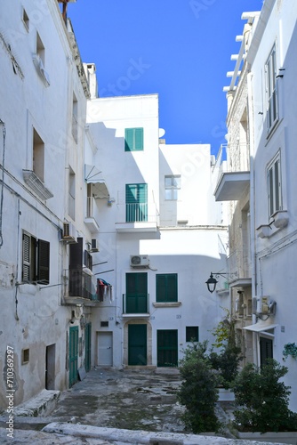A narrow street among the old houses of Monopoli, a town in the province of Bari, Italy.