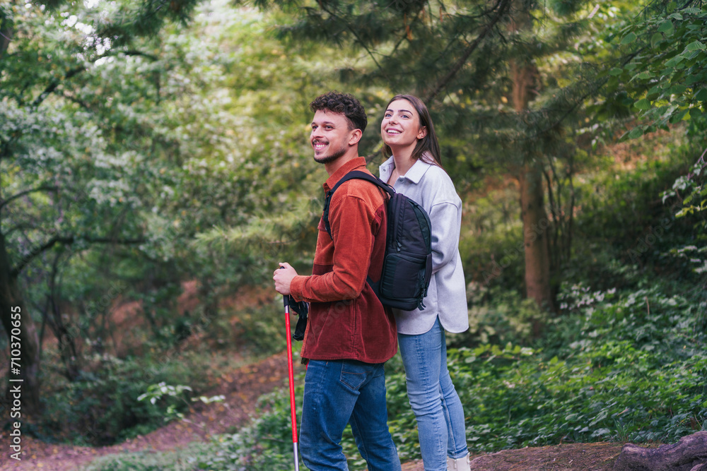 A happy couple stopped during their hike to absorb wonderful nature and breathtaking greenery. They appear to be enjoying their adventure. A happy couple stopped during their hike to absorb wonderful nature and breathtaking greenery. They appear to be enjoying their adventure.
