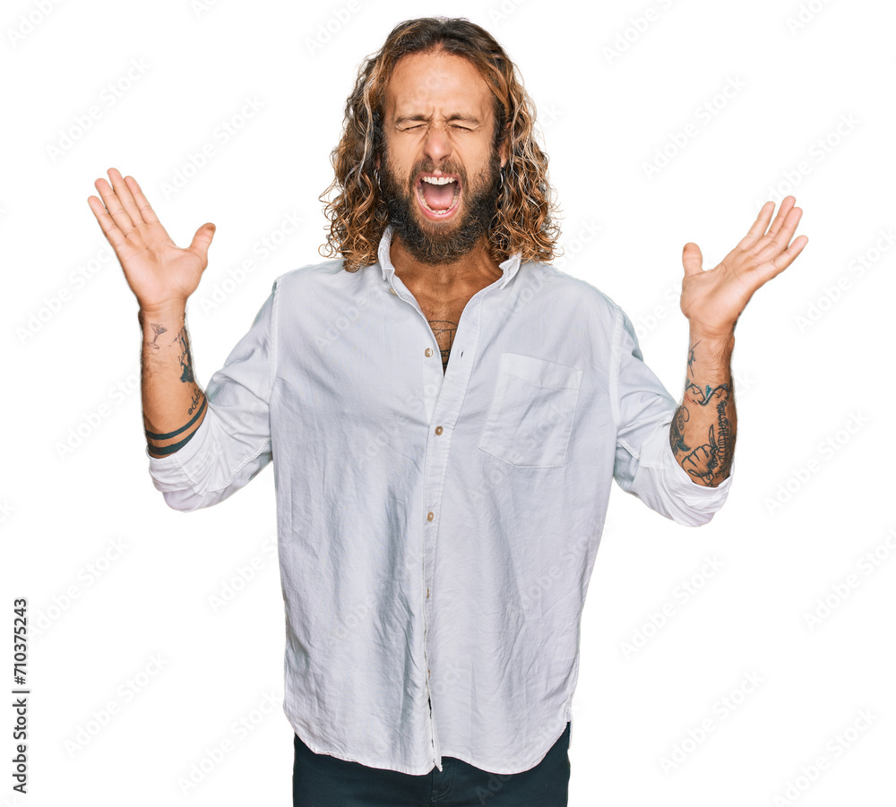 Handsome man with beard and long hair wearing casual clothes celebrating mad and crazy for success with arms raised and closed eyes screaming excited. winner concept Handsome man with beard and long hair wearing casual clothes celebrating mad and crazy for success with arms raised and closed eyes screaming excited. winner concept
