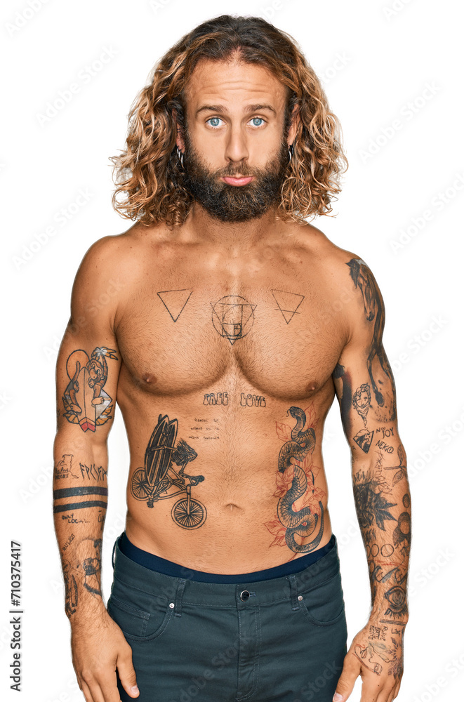 Fototapeta premium Handsome man with beard and long hair standing shirtless showing tattoos depressed and worry for distress, crying angry and afraid. sad expression.