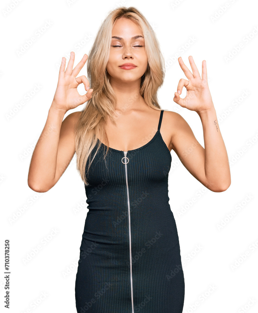 Young blonde girl wearing elegant and sexy look relax and smiling with eyes closed doing meditation gesture with fingers. yoga concept. Young blonde girl wearing elegant and sexy look relax and smiling with eyes closed doing meditation gesture with fingers. yoga concept.