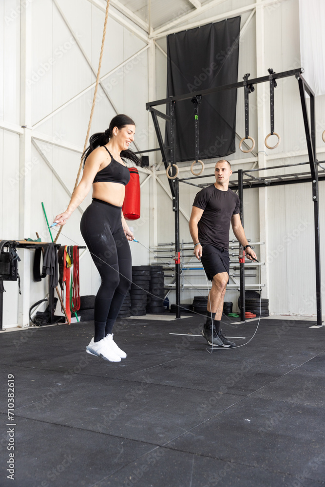 Fototapeta premium Fitness couple jumping on skipping rope in the gym