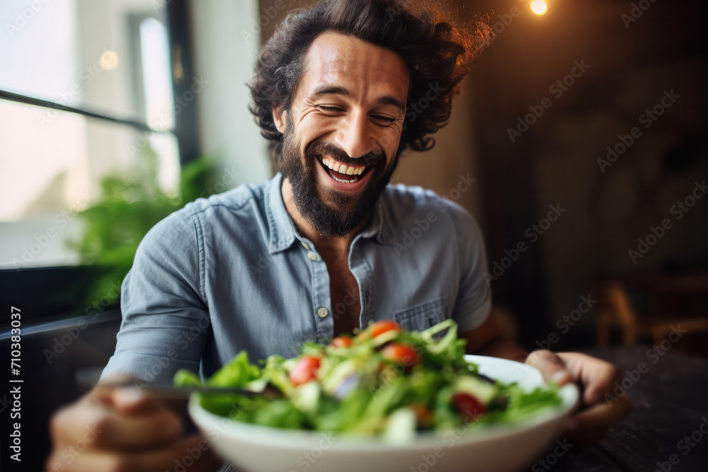 Portrait of a laughing, handsome bearded man enjoying a fresh, healthy vegetable salad at home. Portrait of a laughing, handsome bearded man enjoying a fresh, healthy vegetable salad at home.