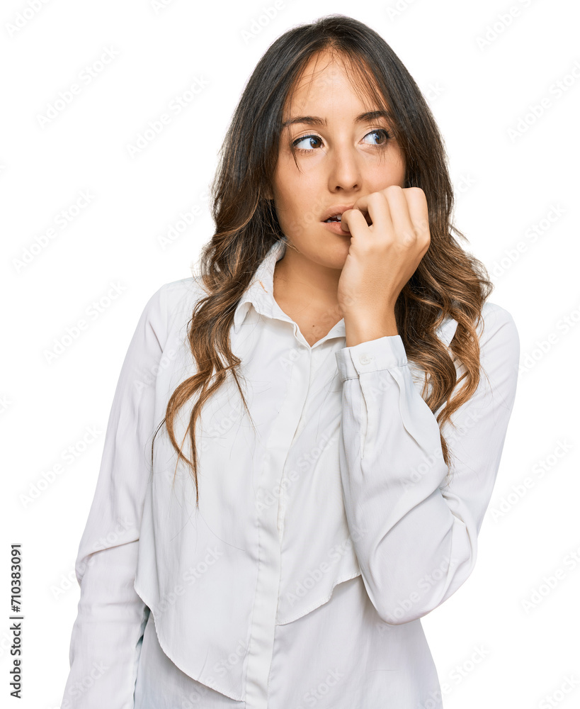 Young brunette woman wearing casual clothes looking stressed and nervous with hands on mouth biting nails. anxiety problem. Young brunette woman wearing casual clothes looking stressed and nervous with hands on mouth biting nails. anxiety problem.