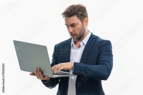 Millennial man in suit working on laptop in studio. Hispanic man checking information on laptop, typing information on laptop. Middle aged man searching information on laptops.