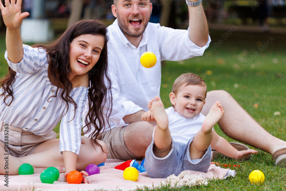 Young parents having fun playing with their toddler boy whille on a picnic Young parents having fun playing with their toddler boy whille on a picnic