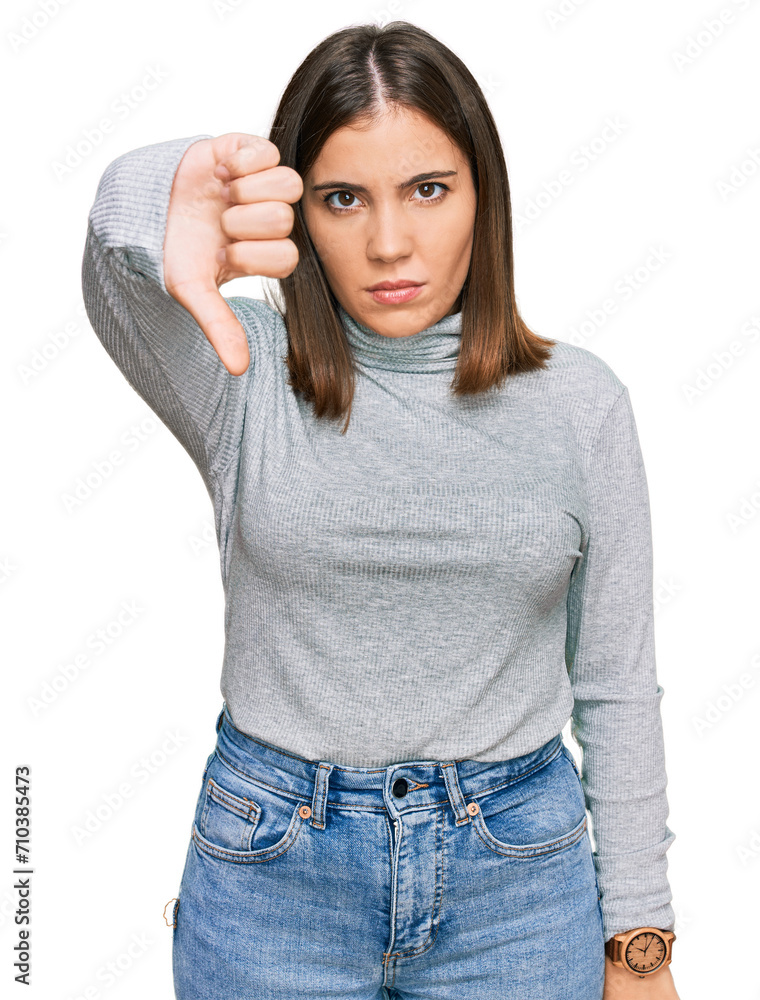 Young beautiful woman wearing casual turtleneck sweater looking unhappy and angry showing rejection and negative with thumbs down gesture. bad expression. Young beautiful woman wearing casual turtleneck sweater looking unhappy and angry showing rejection and negative with thumbs down gesture. bad expression.