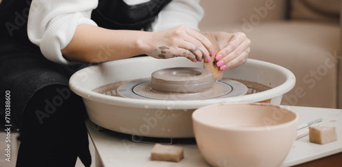 Art workshop place for relax business. Hands young woman with manicure master on potter wheel makes clay dishes