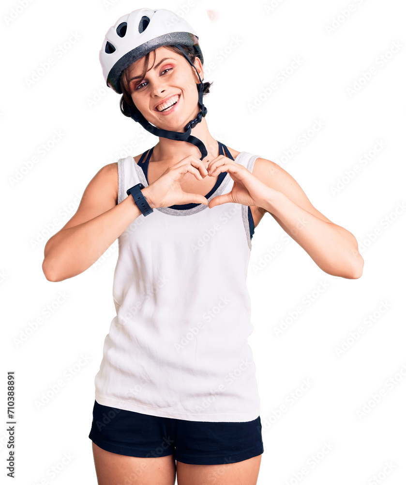 Beautiful young woman with short hair wearing bike helmet smiling in love showing heart symbol and shape with hands. romantic concept. Beautiful young woman with short hair wearing bike helmet smiling in love showing heart symbol and shape with hands. romantic concept.