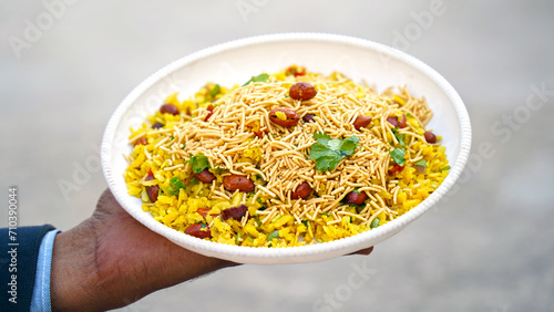 indian breakfast dish poha.Indian breakfast Poha topped with peanuts, pomegranate seeds, chopped green chilly, onion, lime, coriander leaves and curry leaves. photo