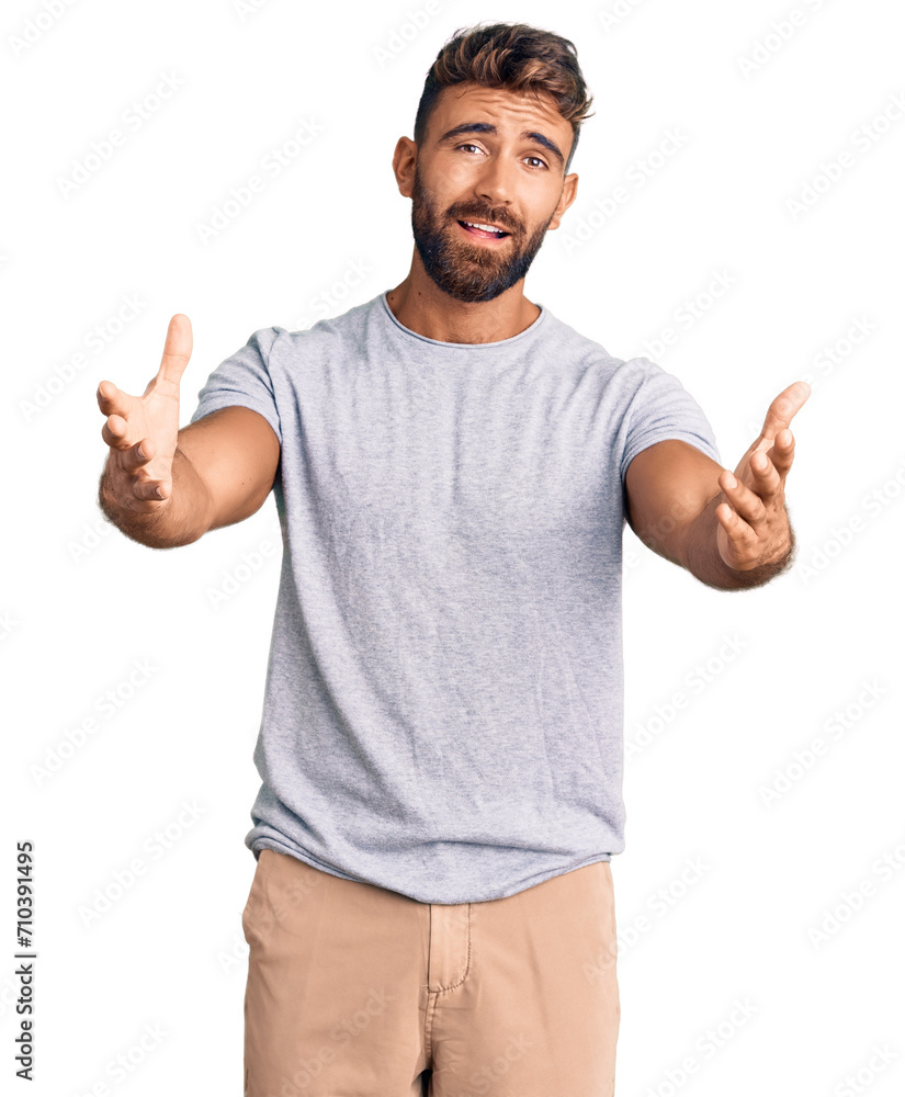 Young hispanic man wearing casual clothes smiling cheerful offering hands giving assistance and acceptance. Young hispanic man wearing casual clothes smiling cheerful offering hands giving assistance and acceptance.