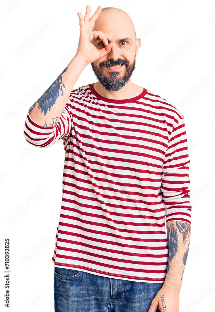Young handsome man wearing casual clothes doing ok gesture with hand smiling, eye looking through fingers with happy face. Young handsome man wearing casual clothes doing ok gesture with hand smiling, eye looking through fingers with happy face.