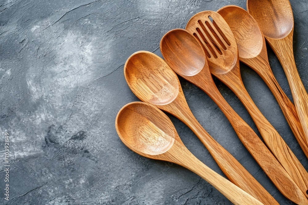 A set of wooden cooking spoons, isolated on a kitchen backdrop A set of wooden cooking spoons, isolated on a kitchen backdrop