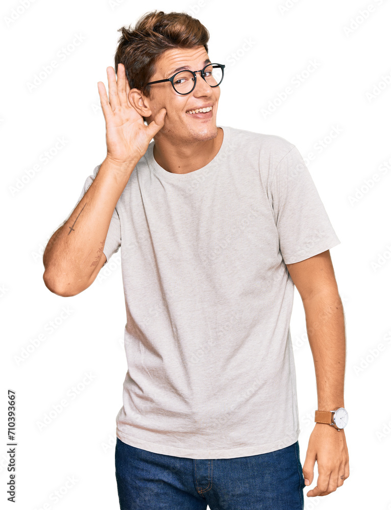 Handsome caucasian man wearing casual clothes and glasses smiling with hand over ear listening an hearing to rumor or gossip. deafness concept.