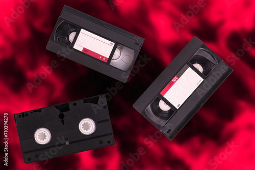 Video cassettes, VHS, Pal Secam, red and black blurred retro background. photo