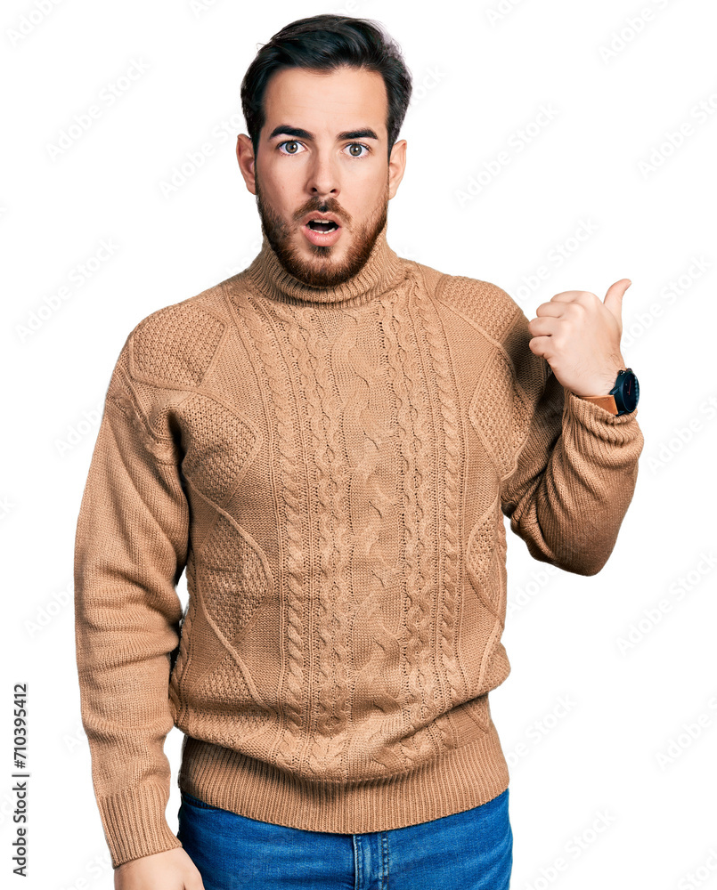 Young hispanic man wearing casual clothes surprised pointing with hand finger to the side, open mouth amazed expression. Young hispanic man wearing casual clothes surprised pointing with hand finger to the side, open mouth amazed expression.