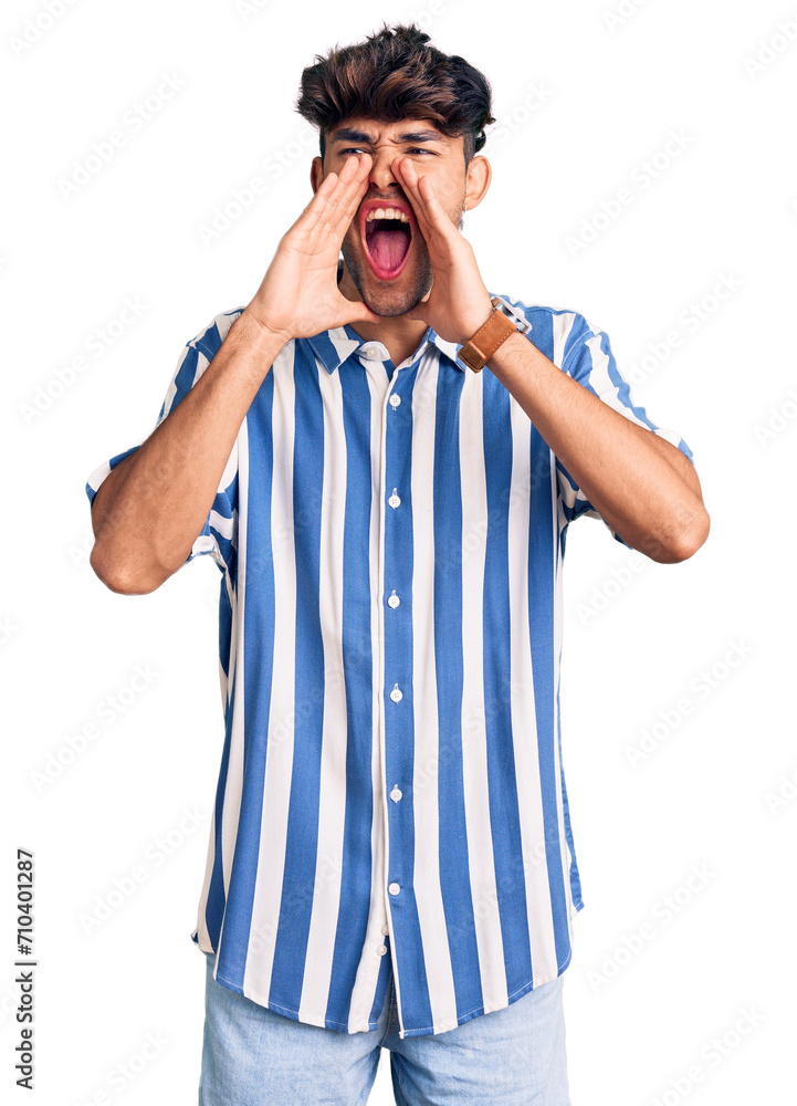 Young hispanic man wearing casual clothes shouting angry out loud with hands over mouth Young hispanic man wearing casual clothes shouting angry out loud with hands over mouth