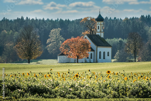 Chapel in the Bavarian foothills of the Alps with sunflowers in the foreground