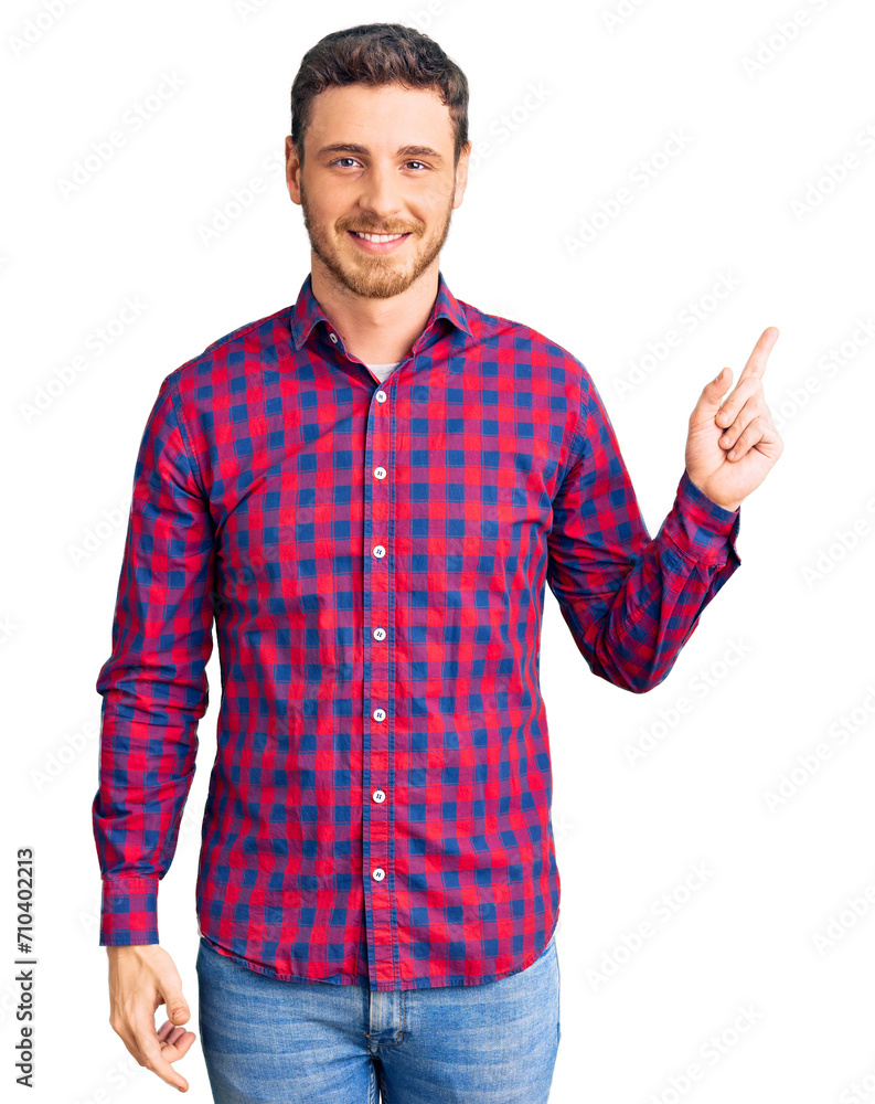 Handsome young man with bear wearing casual shirt with a big smile on face, pointing with hand finger to the side looking at the camera. Handsome young man with bear wearing casual shirt with a big smile on face, pointing with hand finger to the side looking at the camera.