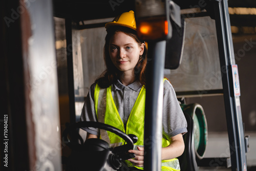 An expert professional Female worker driving forklift in industrial, storehouse or warehouse container. Concept of transportation, installing or loading stock, vehicle service of manufacturing factory