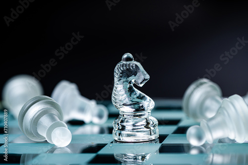 transparent glass chess on dark background, selective focus on horse piece, close-up photo