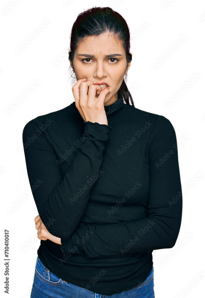Young hispanic woman wearing casual clothes looking stressed and nervous with hands on mouth biting nails. anxiety problem.