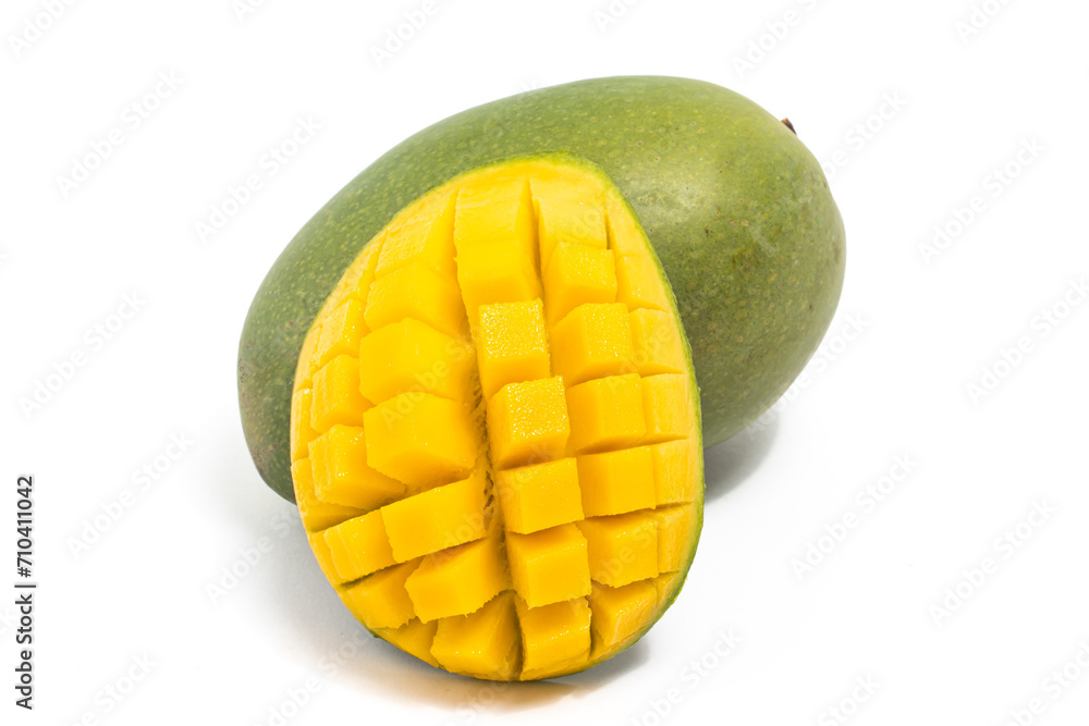 Cut into cubes and whole fresh organic green mango delicious fruit side view isolated on white background clipping path