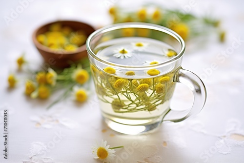 close-up of chamomile flowers in hot water, glass cup