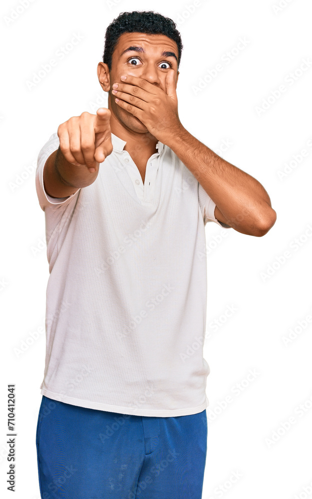 Fototapeta premium Young arab man wearing casual clothes laughing at you, pointing finger to the camera with hand over mouth, shame expression