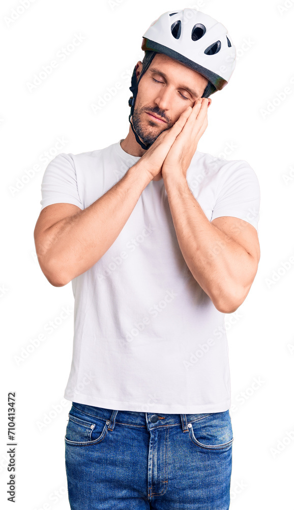 Young handsome man wearing bike helmet sleeping tired dreaming and posing with hands together while smiling with closed eyes. Young handsome man wearing bike helmet sleeping tired dreaming and posing with hands together while smiling with closed eyes.
