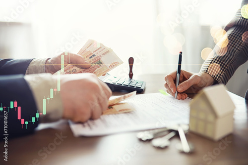 Businessman counting money, Russian ruble currency, while making an agreement contact with his partner in the office - loan and financial concept photo