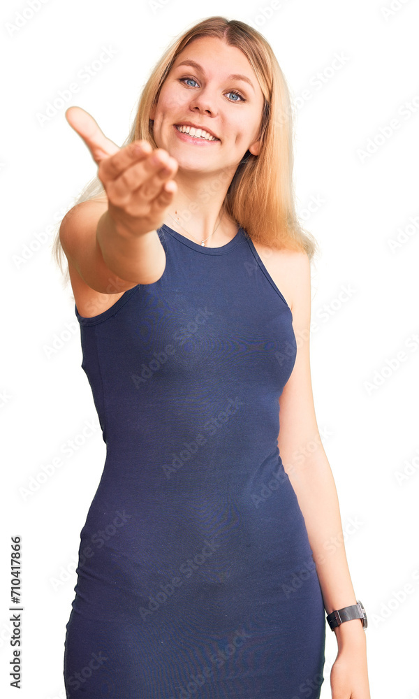 Young beautiful blonde woman wearing casual dress smiling friendly offering handshake as greeting and welcoming. successful business. Young beautiful blonde woman wearing casual dress smiling friendly offering handshake as greeting and welcoming. successful business.