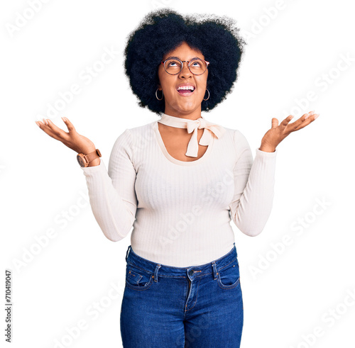 Young african american girl wearing casual clothes and glasses crazy and mad shouting and yelling with aggressive expression and arms raised. frustration concept.