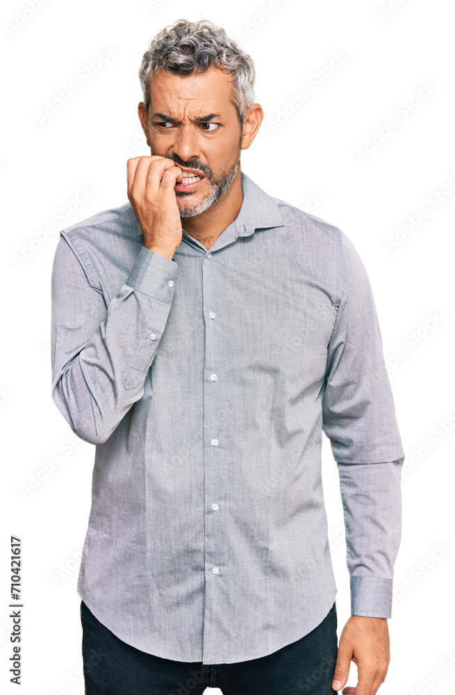 Middle age grey-haired man wearing casual clothes looking stressed and nervous with hands on mouth biting nails. anxiety problem. Middle age grey-haired man wearing casual clothes looking stressed and nervous with hands on mouth biting nails. anxiety problem.