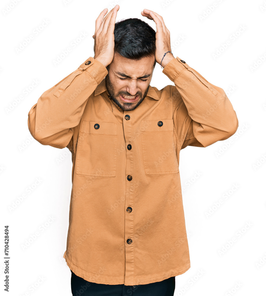 Young hispanic man wearing casual clothes suffering from headache desperate and stressed because pain and migraine. hands on head. Young hispanic man wearing casual clothes suffering from headache desperate and stressed because pain and migraine. hands on head.