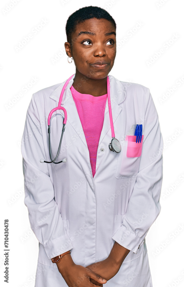 Young african american woman wearing doctor uniform and stethoscope smiling looking to the side and staring away thinking. Young african american woman wearing doctor uniform and stethoscope smiling looking to the side and staring away thinking.