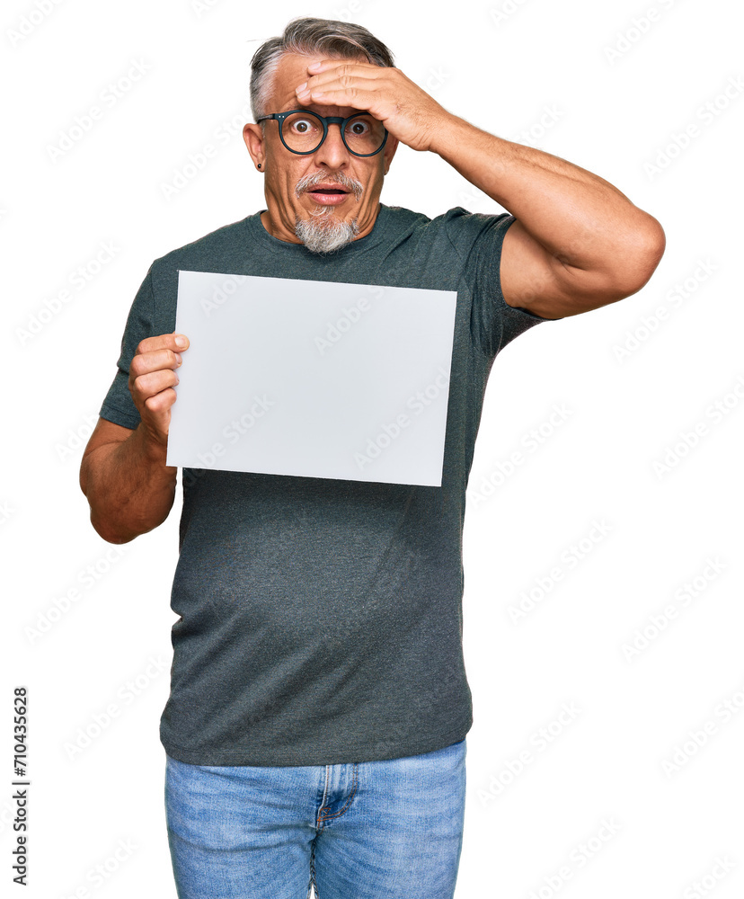 Middle age grey-haired man holding blank empty banner stressed and frustrated with hand on head, surprised and angry face Middle age grey-haired man holding blank empty banner stressed and frustrated with hand on head, surprised and angry face