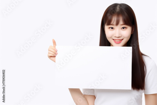 Happy asian scholl girl holding blank white banner sign, isolated studio portrait. © AI_images_for_people