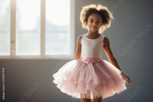 Proud african american little girl on ballet wearing a pink tutu skirt children standing in ballet.