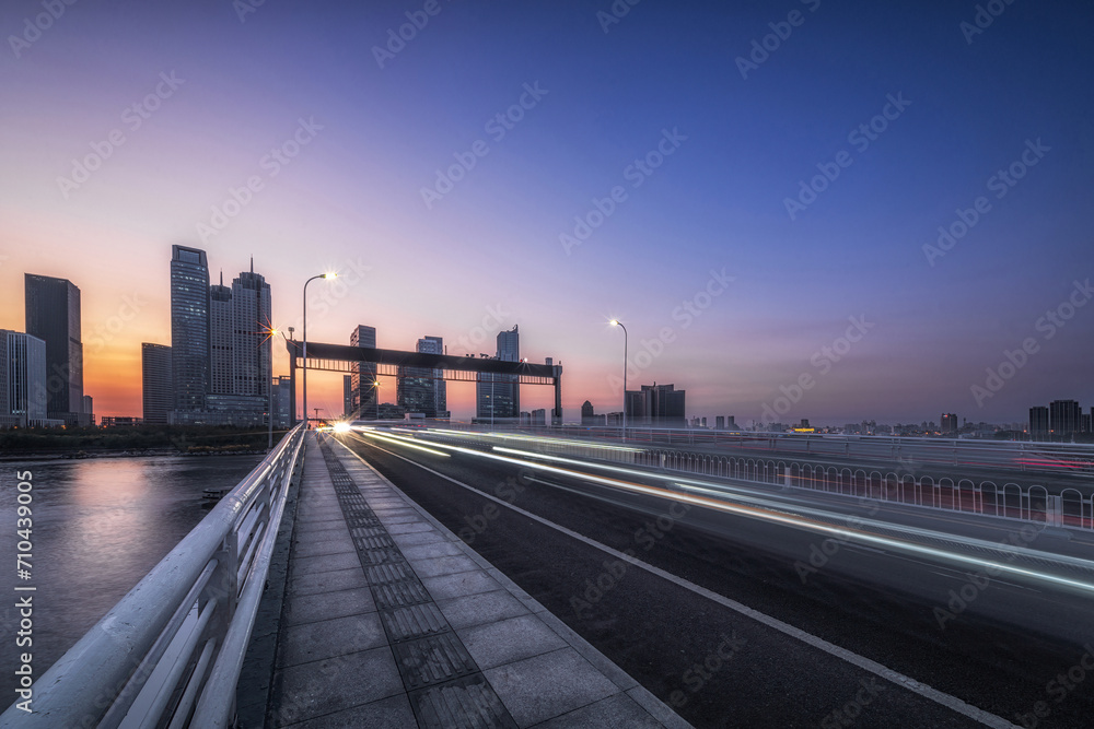 Twilight Cityscape with Light Streaks on Urban Bridge