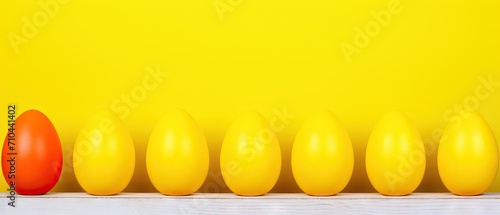 A gradient of colored Easter eggs lined up against a vibrant yellow background