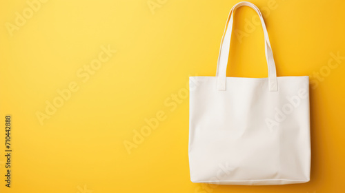 Blank white fabric bag mockup, yellow background photo