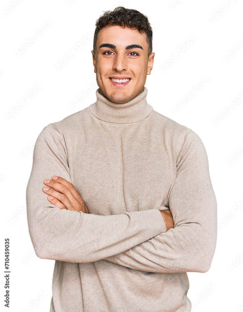 Hispanic young man wearing casual turtleneck sweater happy face smiling with crossed arms looking at the camera. positive person. Hispanic young man wearing casual turtleneck sweater happy face smiling with crossed arms looking at the camera. positive person.