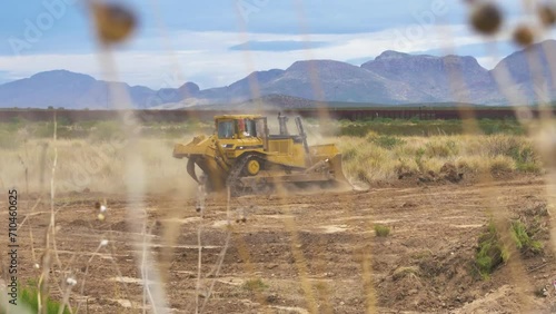 Yellow tracked bulldozer machine on a deserted dirty landscape. Crawler bulldozer machine moving sand. Earth moving machine.