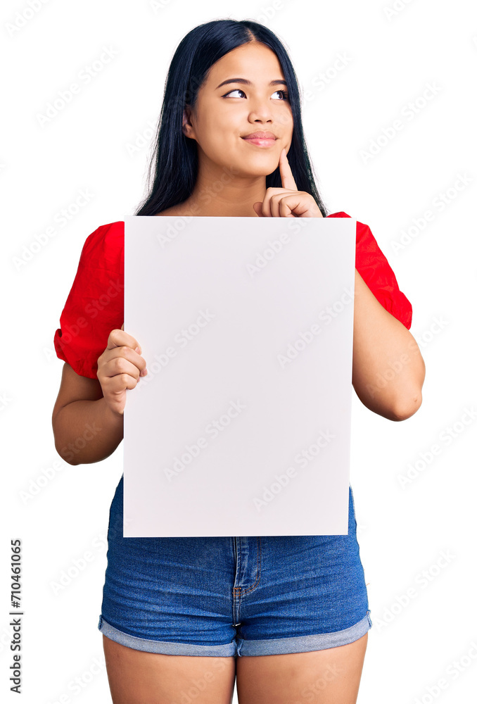 Young beautiful asian girl holding blank empty banner serious face thinking about question with hand on chin, thoughtful about confusing idea Young beautiful asian girl holding blank empty banner serious face thinking about question with hand on chin, thoughtful about confusing idea