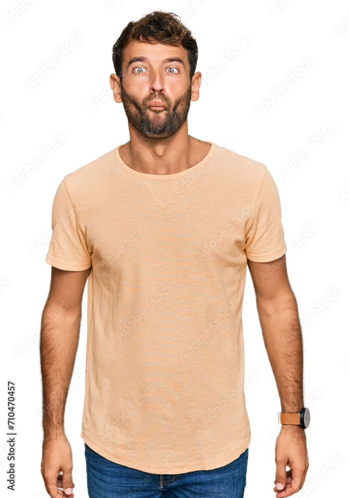 Handsome young man with beard wearing casual tshirt making fish face with lips, crazy and comical gesture. funny expression. Handsome young man with beard wearing casual tshirt making fish face with lips, crazy and comical gesture. funny expression.