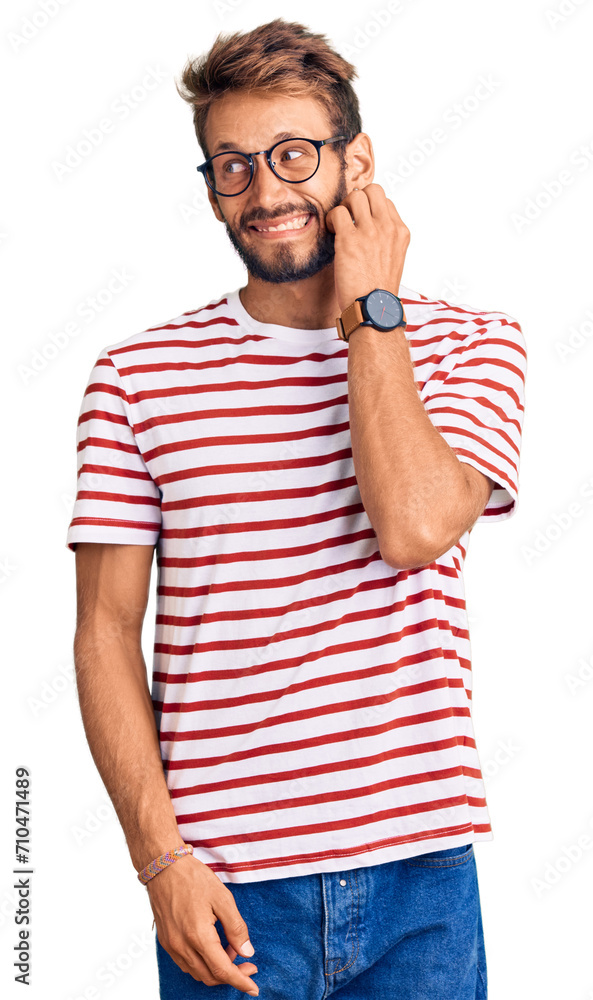 Handsome blond man with beard wearing casual clothes and glasses looking stressed and nervous with hands on mouth biting nails. anxiety problem. Handsome blond man with beard wearing casual clothes and glasses looking stressed and nervous with hands on mouth biting nails. anxiety problem.