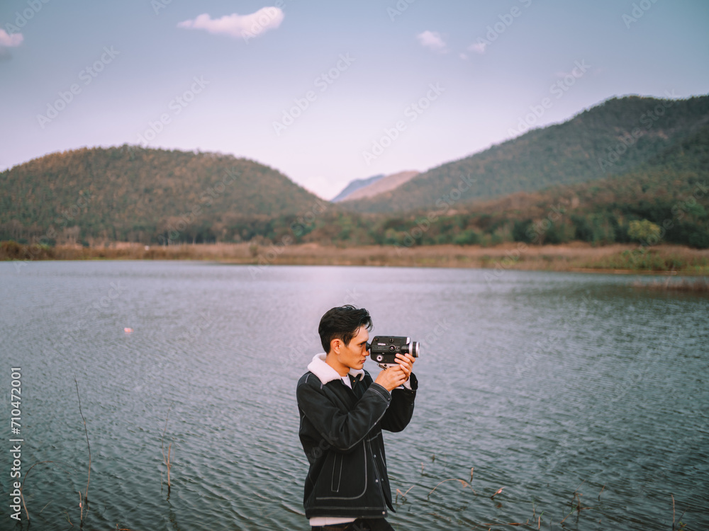Man holding a camera takes pictures of mountain scenery