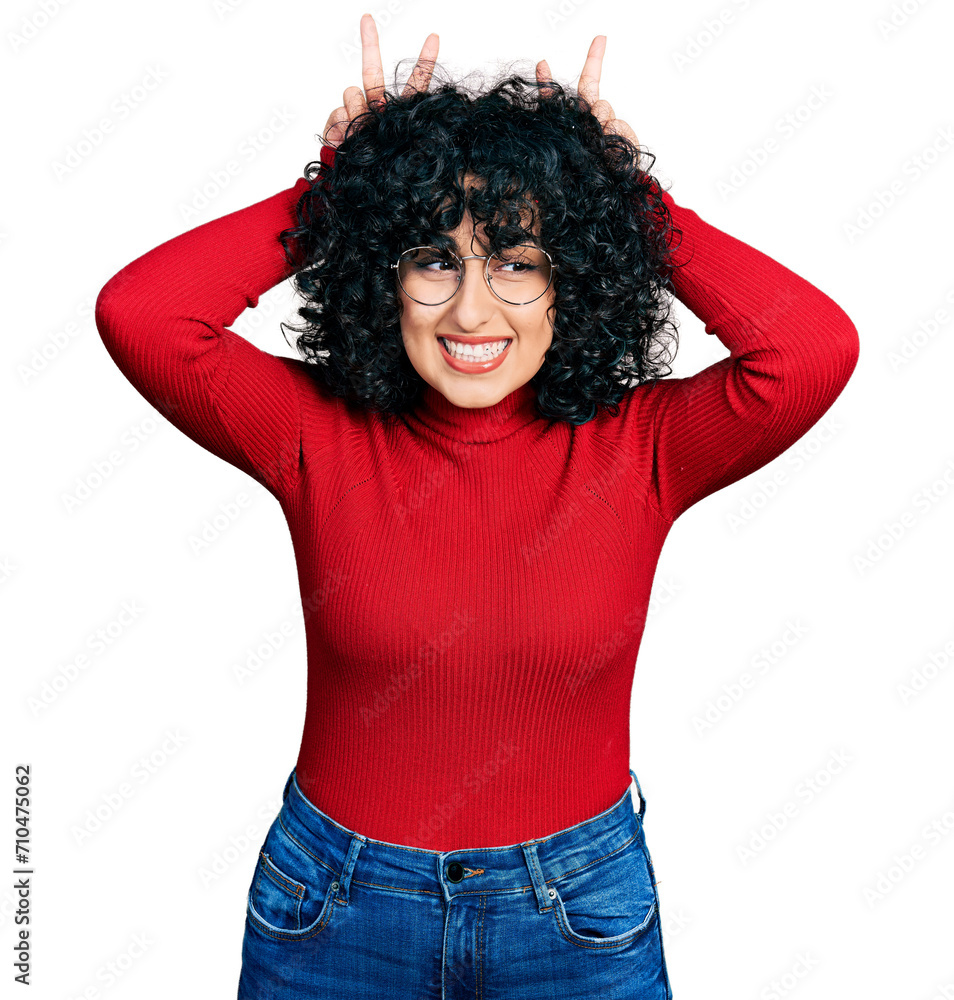 Young middle east girl wearing casual clothes and glasses posing funny and crazy with fingers on head as bunny ears, smiling cheerful Young middle east girl wearing casual clothes and glasses posing funny and crazy with fingers on head as bunny ears, smiling cheerful